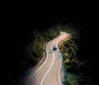 Red Car Driving on a Windy Mountain Road