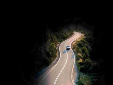 Red Car Driving on a Windy Mountain Road