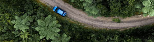 Blue car on teh road aerial view website