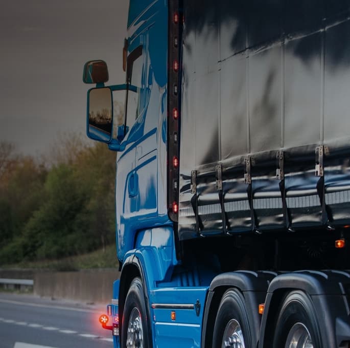 Blue HGV driving on motorway Telematics website